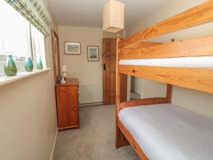 a bedroom with two bunk beds and a window at Shepherds Nook in Chathill
