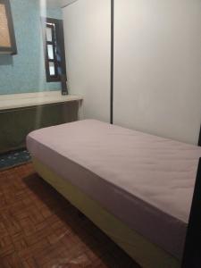 a bed in a room with a white mattress at Chez Hina no Pacifica in Bora Bora