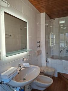 a bathroom with a sink and a toilet and a mirror at Ferienwohnungen Schneiderhäusl inkl. Chiemgaukarte in Ruhpolding +37 photos