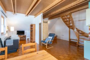 a living room with a staircase and blue chairs at Apartments Rožič Bohinj in Bohinj