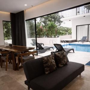 a living room with a black couch and a table at NEW 2 bed swim-up, gril with jacuzzi Aldea Zamá in Tulum