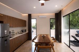 a kitchen and dining room with a wooden table at NEW 2 bed swim-up, gril with jacuzzi Aldea Zamá in Tulum