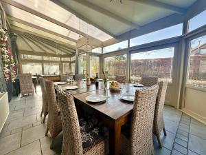 a dining room with a wooden table and chairs at Le Grand Vallon in Polleur