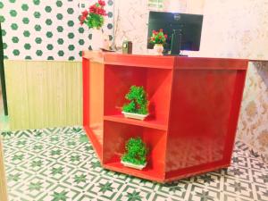a red cabinet with two potted plants on it at Palace inn Hotel in Dargai