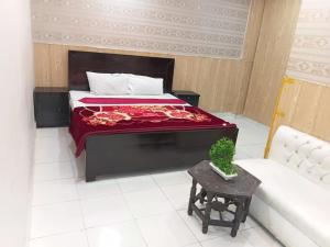 a bedroom with a bed and a table and a couch at Palace inn Hotel in Dargai