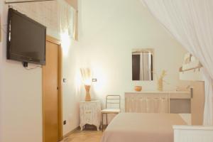 a bedroom with a bed and a tv on the wall at Rubini's House in Giovinazzo