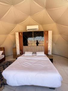 a bedroom with a large bed in a tent at Wadi rum lacshre in Disah