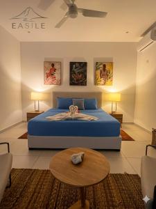 a bedroom with a blue bed and a table at Villa Fontainebleau in Grand-Baie