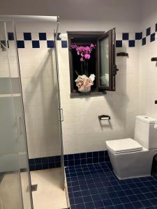 a bathroom with a toilet and a window with flowers at la Tana di Luna in Adrano +24 photos