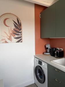 a kitchen with a washing machine and a sink at Les Embruns de Tarnos in Tarnos