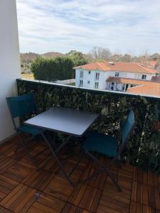 a table and chairs on a balcony with a view at Les Embruns de Tarnos in Tarnos