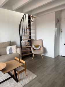 a living room with a couch and a chair at Les Embruns de Tarnos in Tarnos +1 photo