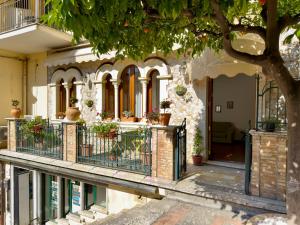 a house with potted plants on a fence at Casa Caterina in Taormina