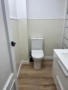 a white bathroom with a toilet and a sink at Casa Portalet in Xàtiva +21 photos