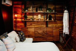 a living room with a white couch and wooden wall at Águila Lodge in San Miguel de Allende