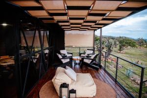 a room with a couch and chairs on a balcony at Águila Lodge in San Miguel de Allende