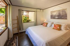 a bedroom with a white bed and a window at Matira Sunset House N659 DTO-MT in Bora Bora