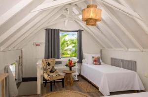 a bedroom with a bed and a chair and a window at Matira Sunset House N659 DTO-MT in Bora Bora +7 photos