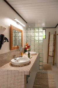 a bathroom with two sinks and a mirror at Matira Sunset House N659 DTO-MT in Bora Bora