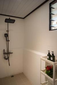 a room with a white wall and a shelf with bottles at Matira Sunset House N659 DTO-MT in Bora Bora