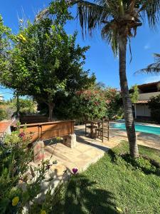 a wooden bench sitting next to a swimming pool at Pousada Casa do Josef in Canoa Quebrada