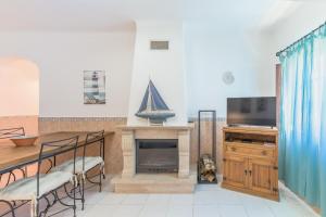 a living room with a tv and a fireplace at Casa da Bé in Vila Nova de Milfontes