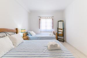 a bedroom with two beds with towels on them at Casa da Bé in Vila Nova de Milfontes