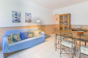 a living room with a blue couch and a table at Casa da Bé in Vila Nova de Milfontes