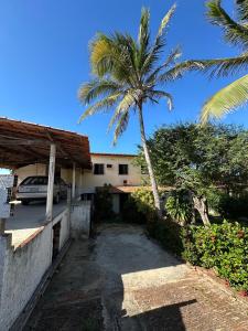 a palm tree in front of a house with a car at Pousada Casa do Josef in Canoa Quebrada