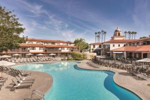a swimming pool with lounge chairs and a resort at Zachari Dunes on Mandalay Beach, Curio Collection by Hilton in Oxnard