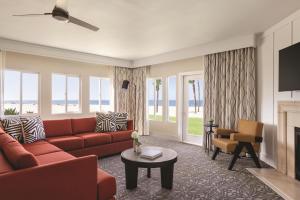 a living room with a red couch and a fireplace at Zachari Dunes on Mandalay Beach, Curio Collection by Hilton in Oxnard