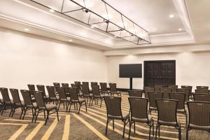 an empty room with chairs and a projection screen at Zachari Dunes on Mandalay Beach, Curio Collection by Hilton in Oxnard +102 photos