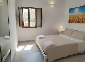 a white bedroom with a bed and a window at Agriturismo Tenuta La Siesta in Gallipoli +177 photos