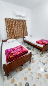 a bedroom with two beds and a curtain at Nilam Guest House in Bodh Gaya
