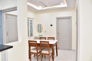 a dining room with white walls and a table and chairs at Beach Flat in Bhīmunipatnam