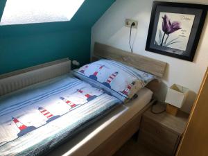 a small bedroom with a bed with blue walls at Ferienhaus Victoria in Norden