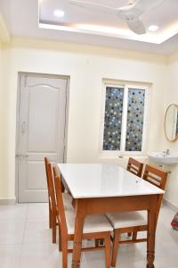 a dining room with a table and chairs and a sink at Beach Flat in Bhīmunipatnam +1 photo