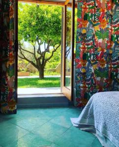 a bedroom with a window with a tree outside at Nonna Maria B&B Home restaurant in La Marinella