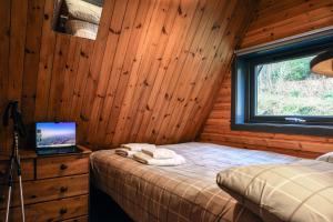 a bedroom with a bed in a wooden cabin at 1 Bedroom Cabin with Mountain & Loch Views - Quiet Location between Glencoe & Ben Nevis in Onich