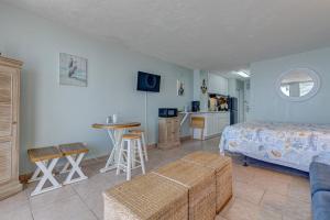 a bedroom with a bed and a table and a kitchen at The Ocean Calls Harbour Beach 612 in Daytona Beach