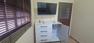 a white refrigerator in a room with a television at Canto dos Pássaros in Brasília +18 photos