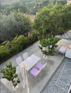 a patio with a table and chairs and trees at Nonna Maria B&B Home restaurant in La Marinella