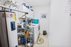 a small kitchen with a refrigerator and a shelf at Sea Woods Home 4205 in New Smyrna Beach +17 photos