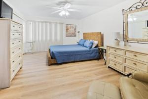a bedroom with a bed and a dresser and a mirror at Sea Woods Home 4205 in New Smyrna Beach