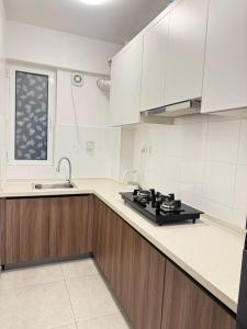 a kitchen with white cabinets and a sink at Snapstay103 in Hulhumale