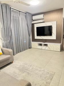 a living room with a television and a couch at Snapstay103 in Hulhumale