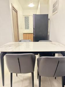 a table and chairs in a room with a refrigerator at Snapstay103 in Hulhumale