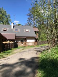 a house with a fence next to a dirt road at Forest Paradise in Stružná