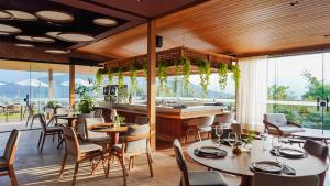 a restaurant with tables and chairs and a bar at Siramat Hotel in Petrópolis