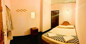a small room with a bed and a mirror at Blue Vibe in Arugam Bay
